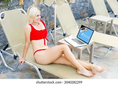 Front View Of Happ Woman Using Laptop While Relaxing On A Sun Lounger In The Backyard At Home. Summer Fun At Home By The Swimming Pool