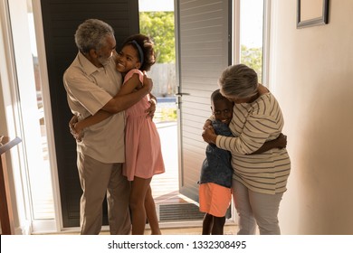 Front View Of Happy African American Grandparents Hugging Their Grandchildren At Home