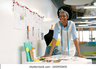 Front view of happy African american female graphic designer leaning on table in office - Powered by Shutterstock