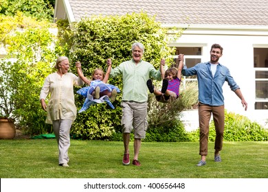 Front view of happy family playing in yard