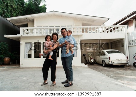Front view of happy family take a photo infront of the house.