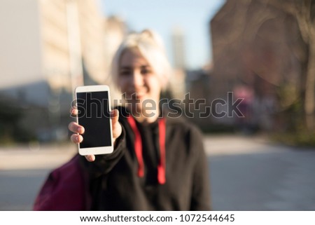 Front view of a happy girl showing a blank smart phone display