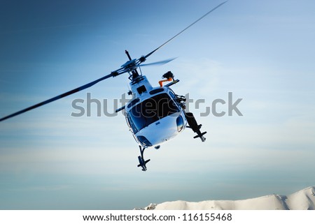 Front view of helicopter in flight. Fly over the snow mountain.