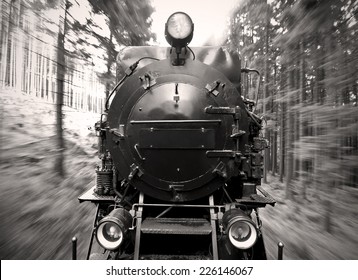 front view of a historic German black steam powered railway train in motion blur, National Park Harz, Germany, sepia tone