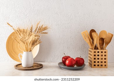 Front view of the kitchen countertop with red apples on the platter and eco-friendly kitchen items. Gray textured wall. - Shutterstock ID 2311252209