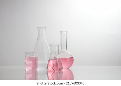 Front view of laboratory equipment filled with pink fluid in a beaker test tube in lab background for experiment advertising 