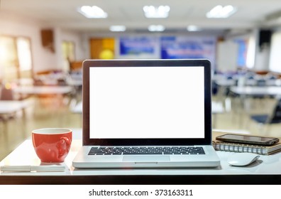 Front view of the laptop and coffee cup is on the work table in meeting room.