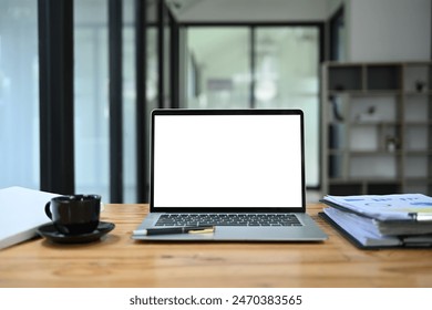 Front view laptop with empty display, documents and coffee cup on wooden office desk - Powered by Shutterstock