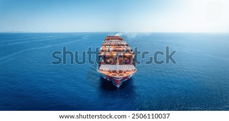 Front view of a large container cargo ship traveling over the calm sea as a banner with copy space