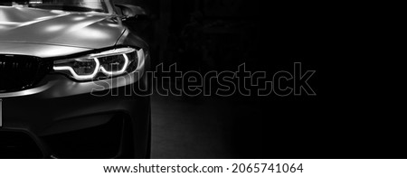 Front view of the LED headlights modern car on black background, copy space