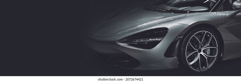Front view of the LED headlights super car on black background, free space on left side for text.