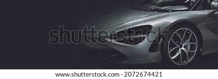 Front view of the LED headlights super car on black background, free space on left side for text.
