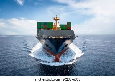 Front View Of A Loaded Container Cargo Vessel Traveling With Speed Over Blue Ocean