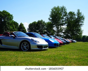 Front view of luxury cars in a row on a green lawn, on a sunny day