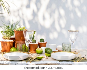Front view of luxury table setting candles, succulents and tropical plants decoration. Table served for engagement, wedding, romantic dinner or event. Outdoor  glamorous catering or dining.