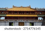 Front view of a main architectural structure (Imperial Gate) with striking yellow tiled roof and green eaves at the Hue Imperial City, Vietnam