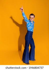 Front view of man dressed in clothing like from 70s on the yellow wall isolated.