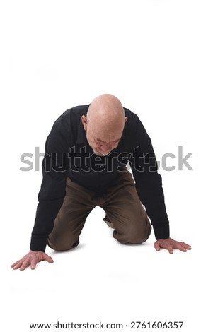 front view of a man kneeling and looking down on white background