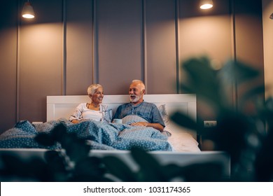 Front View Of A Mature Couple Having Coffee In Bed