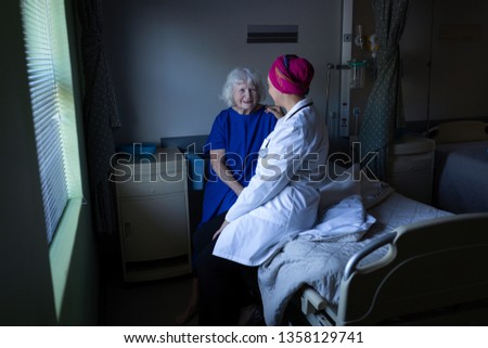 Caregiver helping elderly patient to stand up