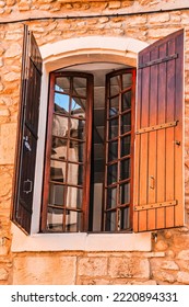 Front View, Medium Distance Of  A Tall Window And Brown Wood Shutters, Of A 1300's Century, Stone, Building