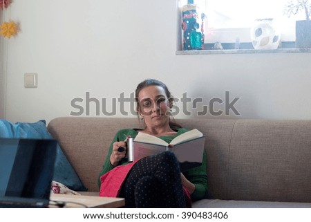 Similar – Happy girl using a smart phone sitting on a couch at home