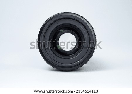 Front View of Mirrorless Camera Lens with Wide Opened Diaphragm on Isolated White Background