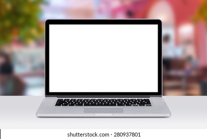 Front View Of Modern Laptop Mockup With White Blank Screen On The Office Desk. Coffee Shop On The Background. 