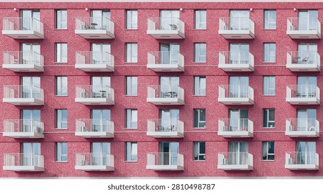 Front View of a Modern Red Brick Apartment Building with Repeating White Balconies and Windows