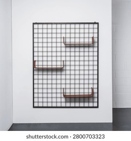 Front view of a modular wall-mounted bookcase with a metal frame and curved wooden shelves.