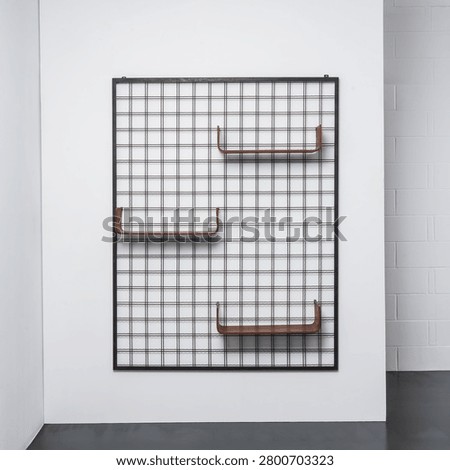 Front view of a modular wall-mounted bookcase with a metal frame and curved wooden shelves.