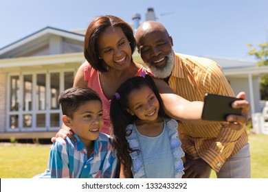 Front View Of A Multi-generation African American Family Taking Selfie With Mobile Phone At The Backyard Of Home