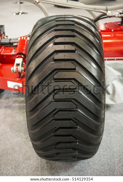 Front view of new big tire wheel of\
agricultural machine on\
exhibition