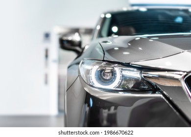 front view of new modern silver car led headlight in showroom - Shutterstock ID 1986670622