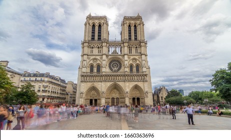 Front view of Notre-Dame de Paris timelapse  is a medieval Catholic cathedral on the Cite Island in Paris, France. Long queue of tourists. Cloudy sky at summer day