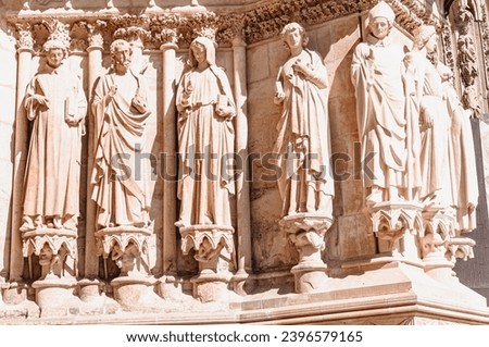 front view of, a carved stone sculpture, on exterior limestone block wall, in Reims, France
