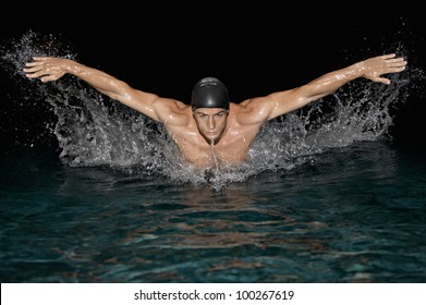 Front View Of An Olympic Swimmer Training For The Butterfly Stroke In A Swimming Pool.