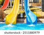 front view on blue and yellow waterslide at aquapark outdoor pool