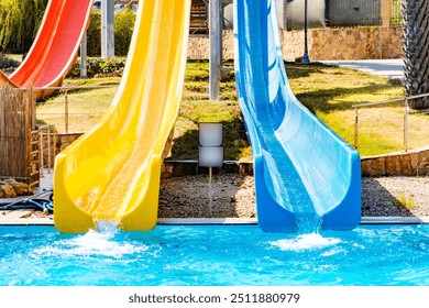 front view on blue and yellow waterslide at aquapark outdoor pool