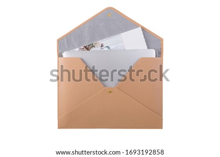 Front view of a opened light brown personal file folder with notebook and magazine isolated on a white background.