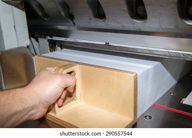 Front View Of A Paper Guillotine Used In Commercial Printing Industry. Industrial Knife Cutter. Man's Hand Pushes The Paper With Special Paper Pusher