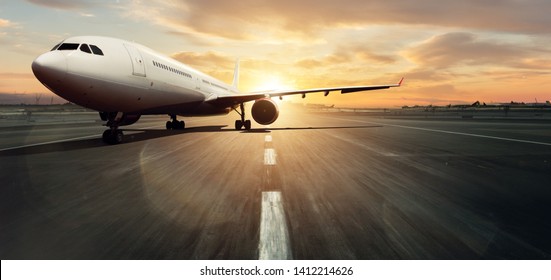 Front view of parked commercial airplane on runway. Modern and fastest mode of transportation. Dramatic sunset sky on background