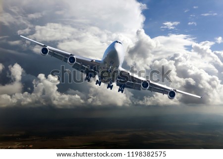 Front view of the passenger plane in flight. Right heeling of aircraft. Thunderclouds in the airplane background.