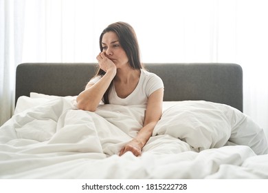 Front view of a pensive woman with her head propped on her hand looking away - Powered by Shutterstock