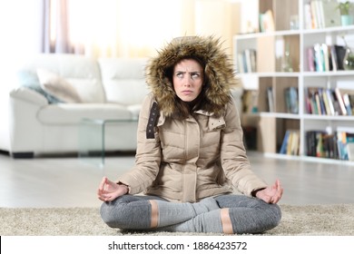 Front View Portrait Of An Angry Woman With Damaged Heater At Home Trying To Relax Doing Yoga Exercise