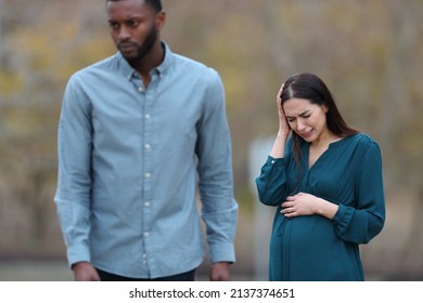 Front View Portrait Of A Breakup With A Husband Leaving His Sad Pregnant Wife In A Park