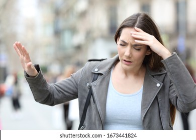 Front View Portrait Of A Dizzy Young Woman Feeling Sick On A City Street