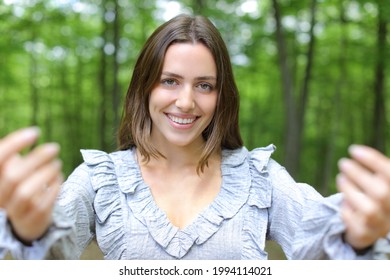 Front View Portrait Of A Happy Woman Saying Come Here Beckoning With Both Hands In A Park