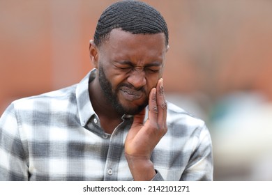 Front view portrait of a man with black skin complaining about tooth ache - Shutterstock ID 2142101271