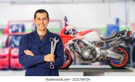 Front view portrait of a motorcycle mechanic posing standing looking at you in a mechanical workshop and copy space - Powered by Shutterstock